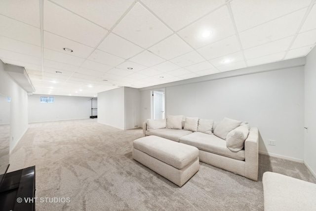 living room featuring carpet flooring, a paneled ceiling, and baseboards