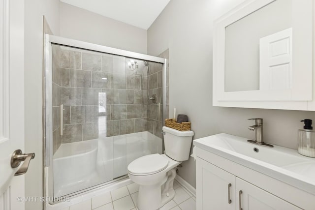 bathroom featuring toilet, a stall shower, vanity, and tile patterned floors