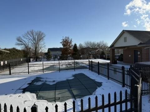 snow covered pool with fence and a fenced in pool