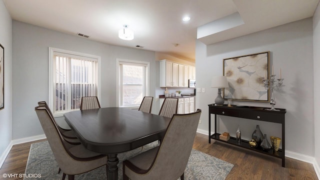 dining room featuring baseboards, visible vents, and dark wood finished floors