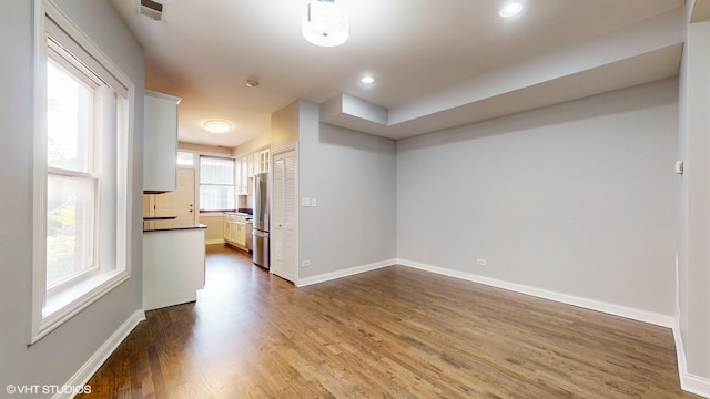 empty room with baseboards, visible vents, wood finished floors, and recessed lighting