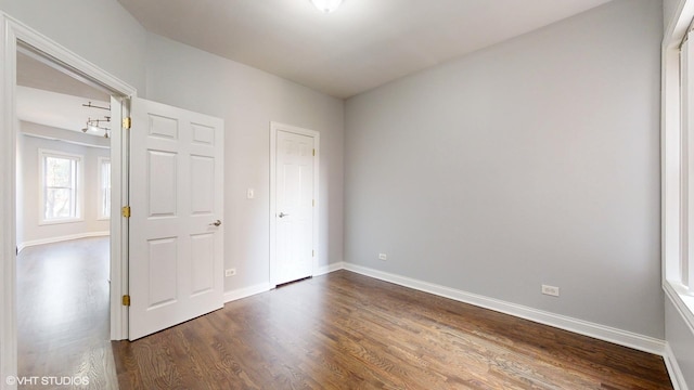 unfurnished bedroom with dark wood finished floors and baseboards