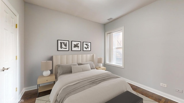 bedroom featuring visible vents, baseboards, and dark wood finished floors