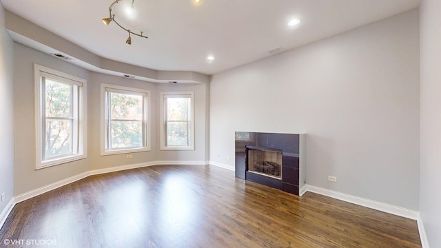 unfurnished living room featuring dark wood-style flooring, a fireplace, recessed lighting, visible vents, and baseboards