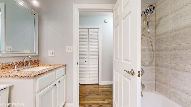 bathroom featuring bathtub / shower combination, wood finished floors, a closet, and vanity