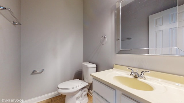 half bathroom featuring tile patterned flooring, baseboards, vanity, and toilet