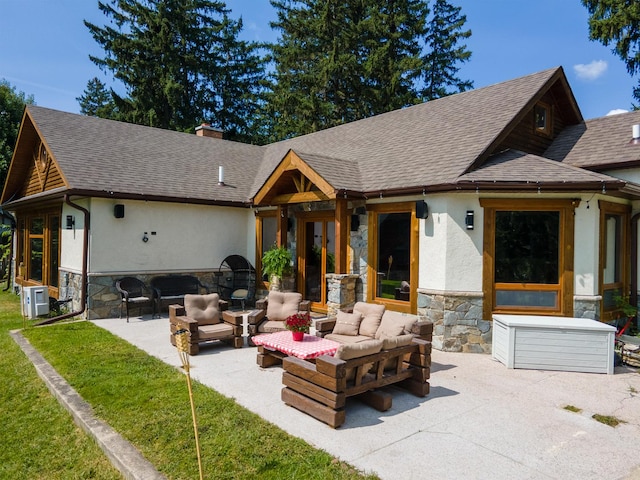 back of house featuring stucco siding, a shingled roof, an outdoor hangout area, a patio area, and stone siding