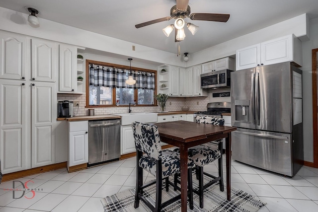 kitchen with stainless steel appliances, white cabinetry, and open shelves