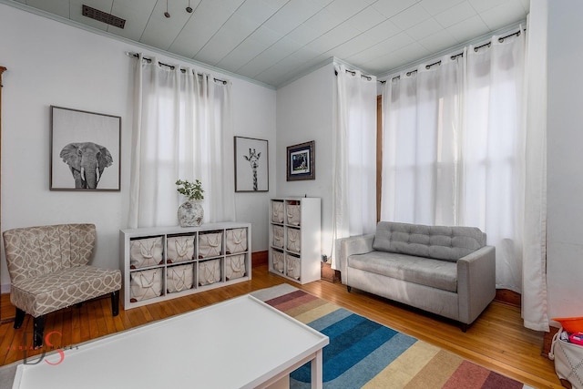 sitting room featuring wood finished floors, visible vents, and a healthy amount of sunlight