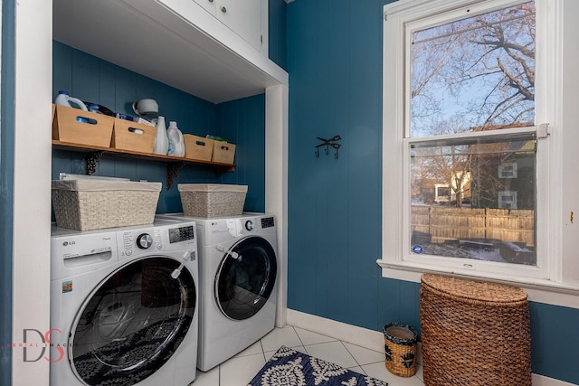 laundry area featuring light tile patterned floors, cabinet space, and washer and dryer