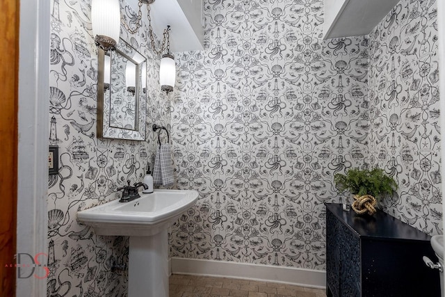 bathroom featuring baseboards and wallpapered walls