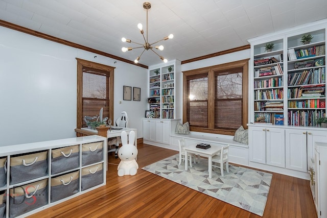 interior space with a notable chandelier, built in shelves, ornamental molding, and dark wood-style flooring