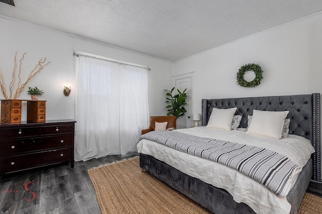 bedroom with dark wood-style floors, ornamental molding, and a textured ceiling