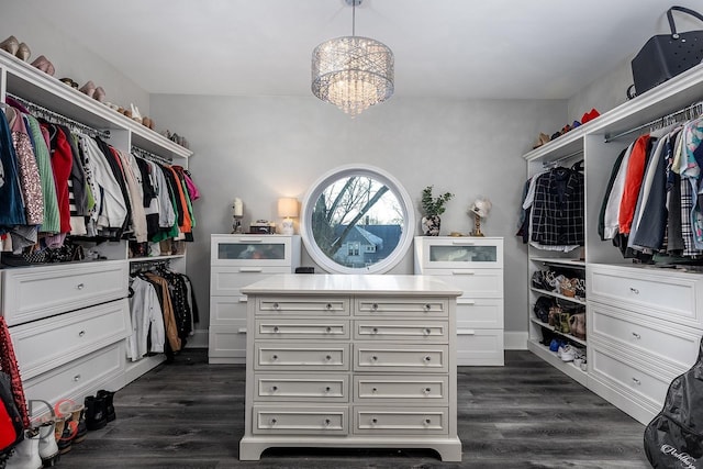 spacious closet with dark wood-style floors and an inviting chandelier