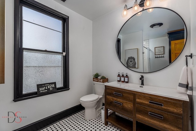 bathroom with vanity, toilet, and baseboards