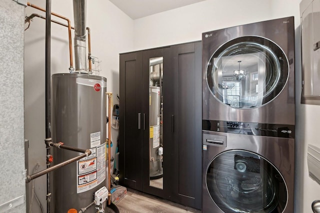 laundry area with light wood-style floors, stacked washer / dryer, gas water heater, and laundry area