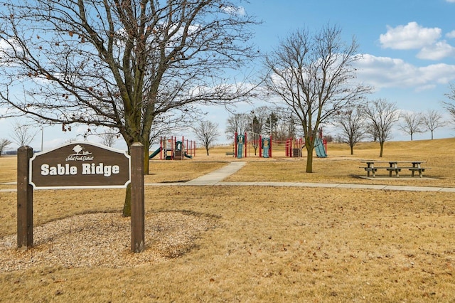 view of home's community with a lawn and playground community