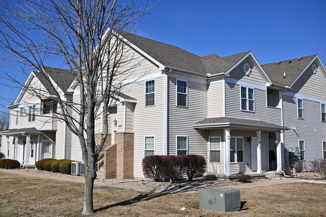 view of front of house with central air condition unit and a shingled roof