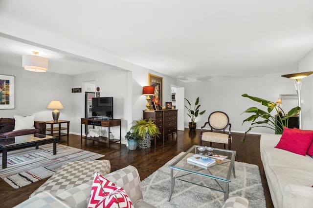 living room featuring dark wood-type flooring and baseboards