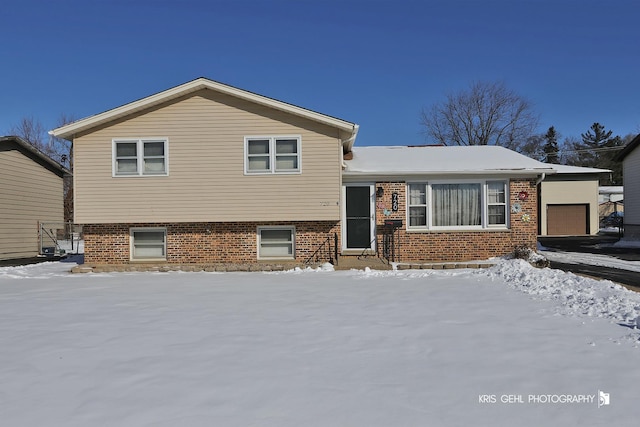 split level home with brick siding and an attached garage