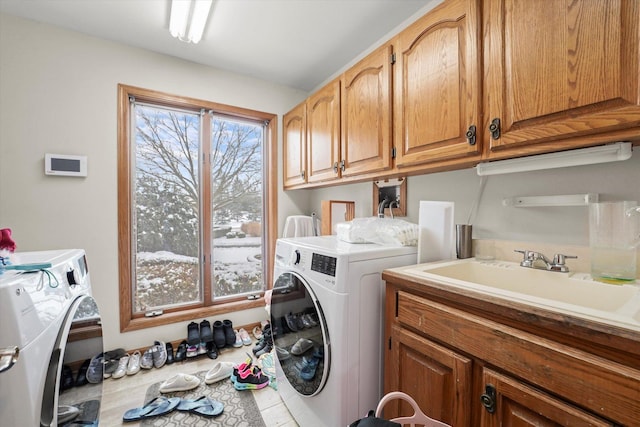 laundry area with cabinet space, a sink, and washing machine and clothes dryer