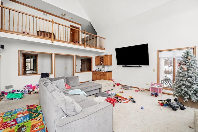 carpeted living room featuring high vaulted ceiling and visible vents