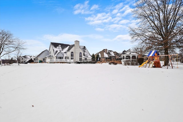 snow covered property with a playground and a residential view