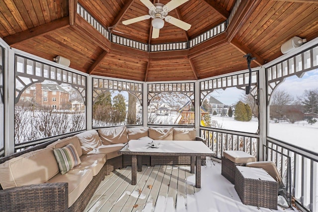 sunroom featuring a ceiling fan, lofted ceiling, and wood ceiling