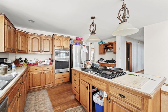 kitchen with brown cabinets, a center island, decorative light fixtures, stainless steel appliances, and light countertops