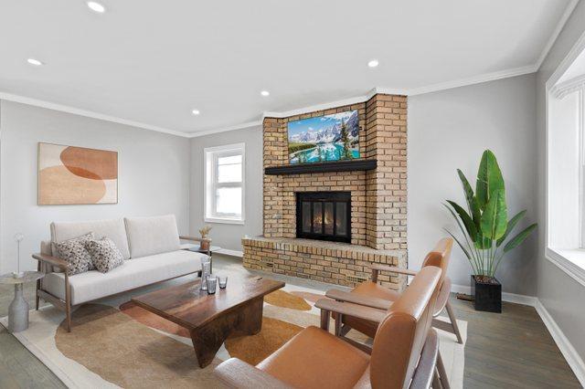 living area featuring crown molding, baseboards, and wood finished floors