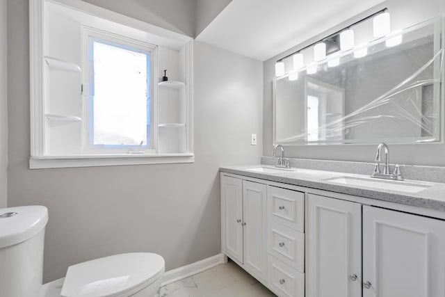 full bath featuring marble finish floor, baseboards, a sink, and toilet