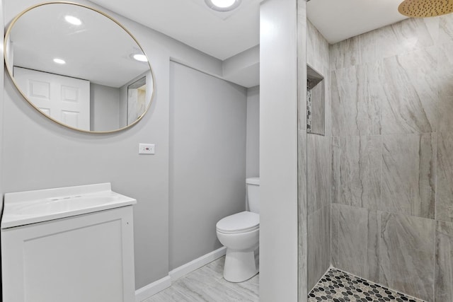 full bath with baseboards, toilet, a tile shower, vanity, and recessed lighting