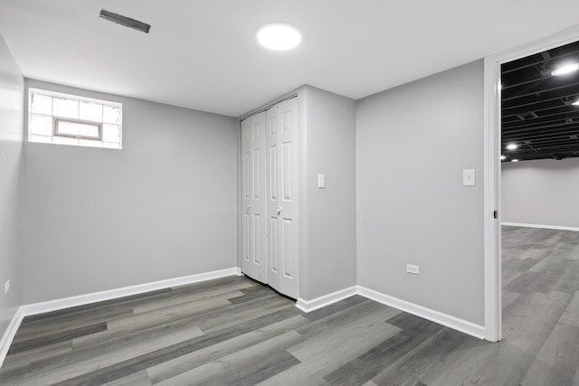 below grade area with baseboards and wood finished floors