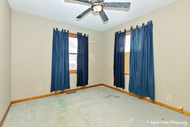 empty room with baseboards, visible vents, and a ceiling fan