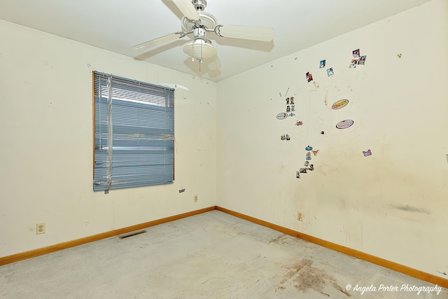 empty room featuring ceiling fan, visible vents, and baseboards