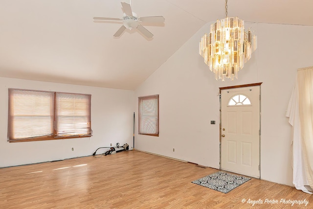 entryway with light wood finished floors, high vaulted ceiling, and ceiling fan with notable chandelier