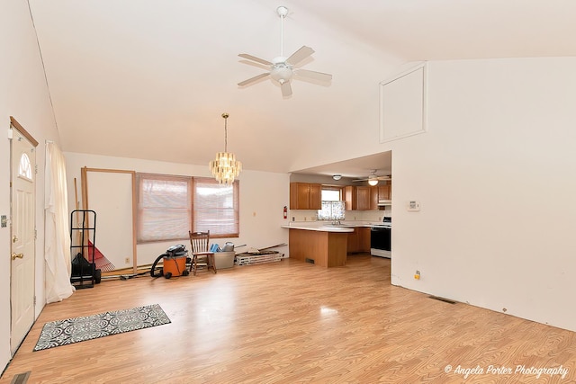 living area featuring ceiling fan with notable chandelier, high vaulted ceiling, visible vents, and light wood-style floors