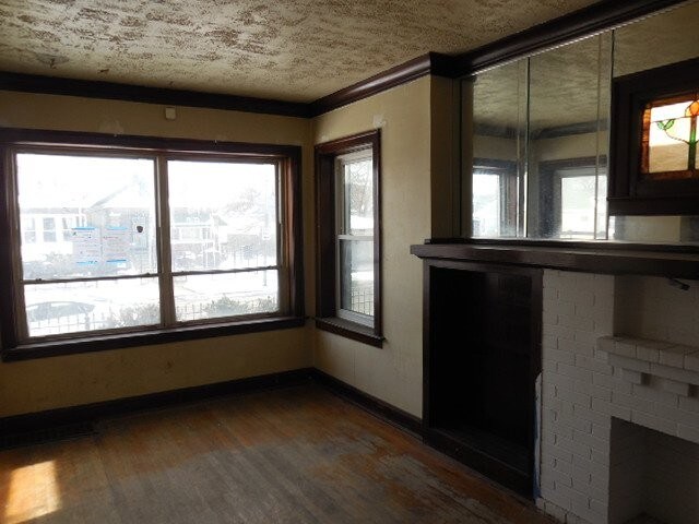 interior space featuring a fireplace, baseboards, and wood finished floors