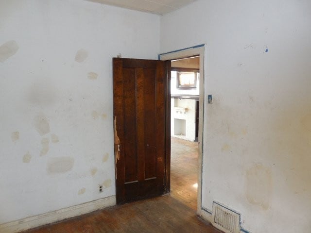 spare room featuring dark wood finished floors and visible vents