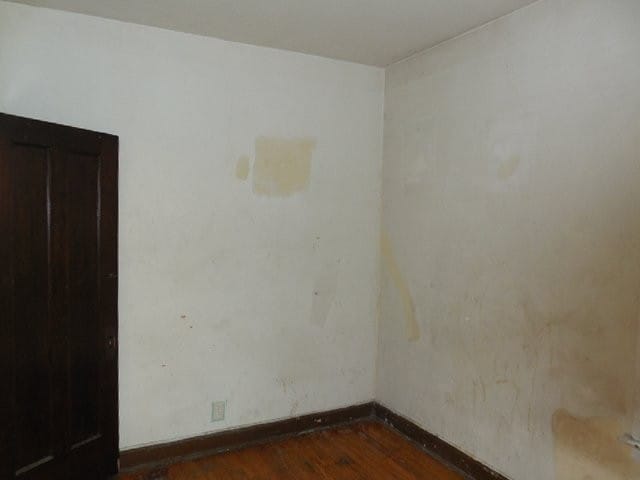 unfurnished room with dark wood finished floors and baseboards