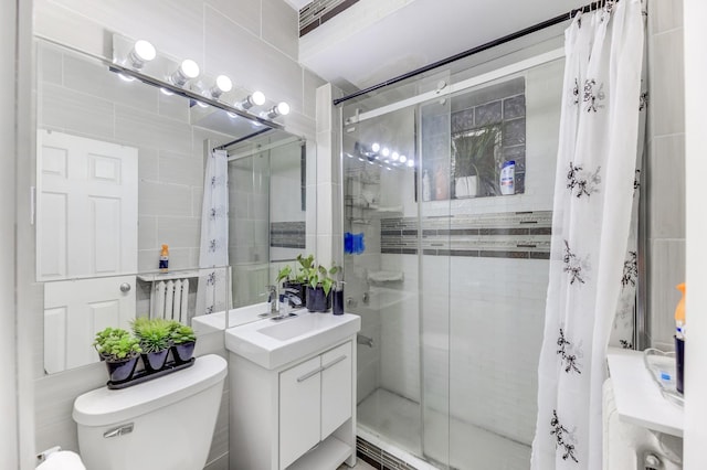 full bathroom featuring toilet, a shower stall, tile walls, and vanity