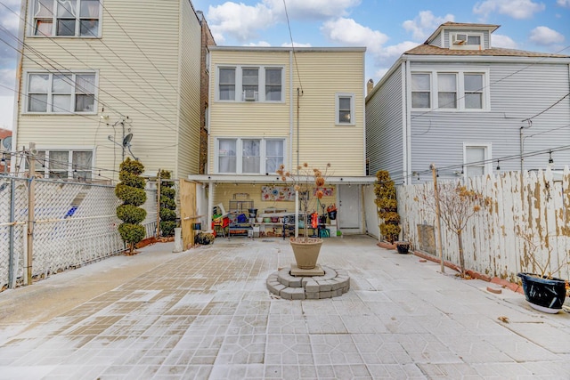 rear view of property featuring a fenced backyard and a patio