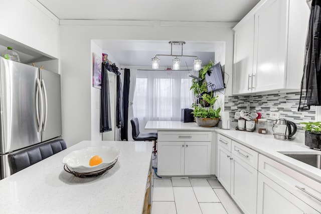 kitchen featuring ornamental molding, freestanding refrigerator, white cabinetry, and decorative backsplash