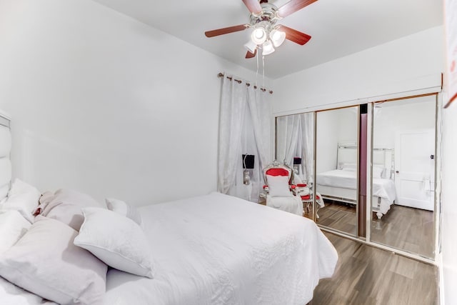 bedroom featuring a closet, wood finished floors, and a ceiling fan