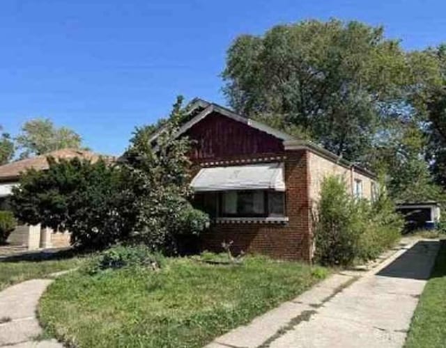 view of home's exterior featuring brick siding and a yard