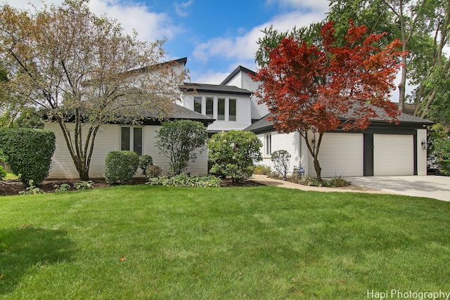 view of front facade featuring a garage, concrete driveway, and a front lawn