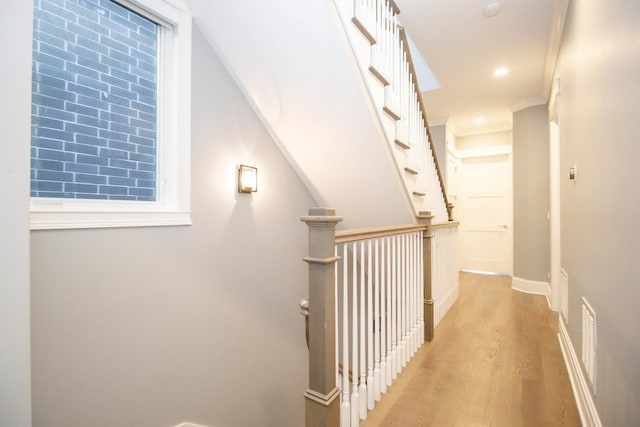 corridor featuring recessed lighting, visible vents, baseboards, light wood-style floors, and ornamental molding