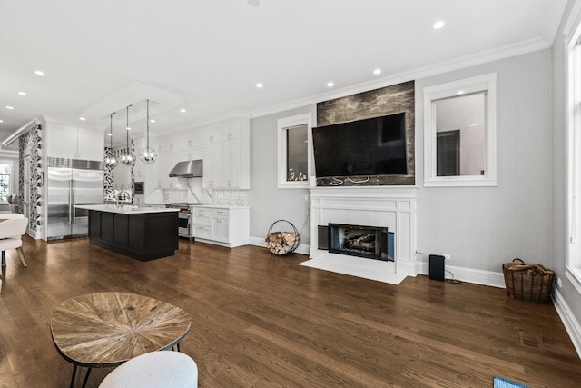 living room with a large fireplace, visible vents, dark wood-type flooring, and crown molding