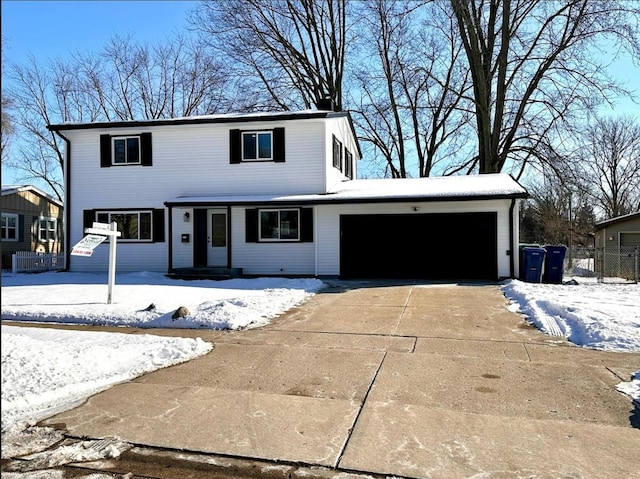 traditional-style house featuring a garage and concrete driveway