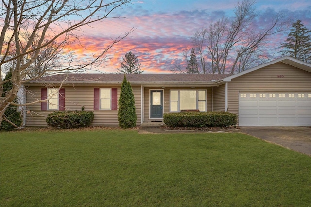 ranch-style home with an attached garage, driveway, and a yard